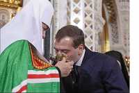 Медведев целует крест в церкви
